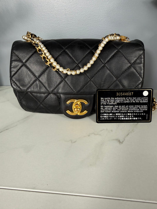 2275. Chanel Black Quilted Lambskin Pearl Chain Mini Flap Bag